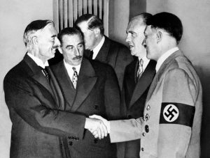 Hands clasped in friendship, Adolf Hitler and England's Prime Minister Neville Chamberlain, are shown in this historic pose at Munich on Sept. 30, 1938. This was the day when the premier of France and England signed the Munich agreement, sealing the fate of Czechoslovakia. Next to Chamberlain is Sir Neville Henderson, British Ambasador to Germany. Paul Schmidt, an Interpreter, stands next to Hitler. (AP Photo)